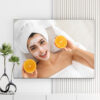 Mẫu tranh spa đẹp hình ảnh cô gái đắp mặt nạ và tạo dáng với hai miếng cam chín vàng