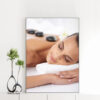 Mẫu tranh spa đẹp khổ đứng hình ảnh cô gái nằm thư giãn với đá cuội đen nóng chườm trên lưng, nền khăn tắm trắng muốt