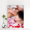 Mẫu tranh spa đẹp khổ đứng hình ảnh nhân viên dùng túi chườm massage thư giãn cho khách hàng với hoa ly tím và cánh hoa hồng rải xung quanh