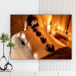 Mẫu tranh spa đẹp hình ảnh cô gái nằm thư giãn chườm đá nóng trong không gian ánh nến vàng ấm áp