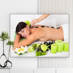 Mẫu tranh spa đẹp hình ảnh nhân viên chườm đá nóng trên lưng cô gái, bên cạnh là nến thơm và hoa sen